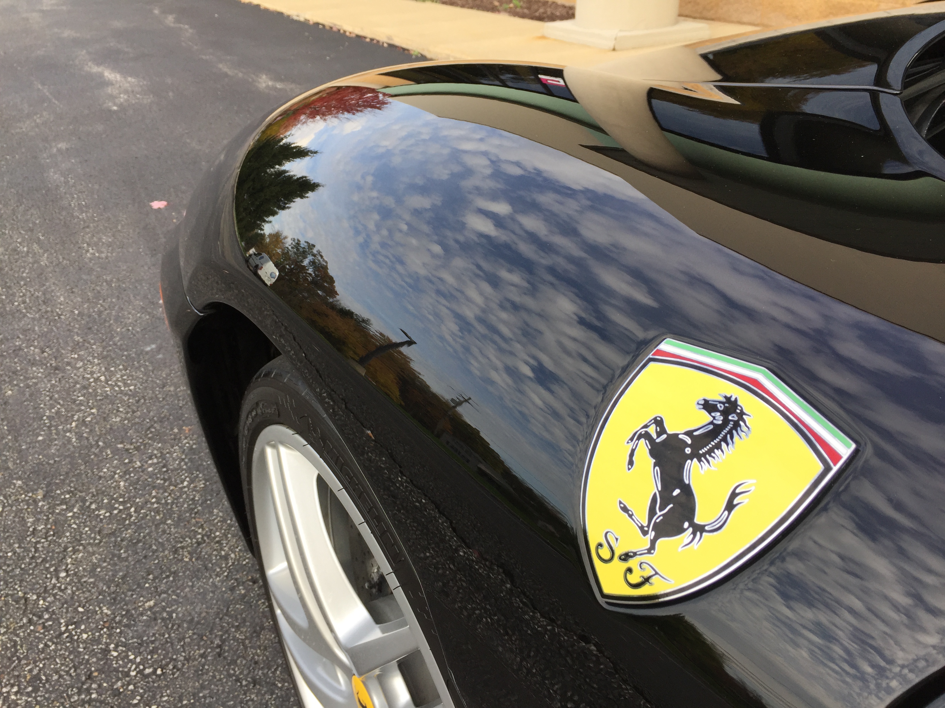 Ferrari F430 — mirror-finish paint correction showing cloud reflections
